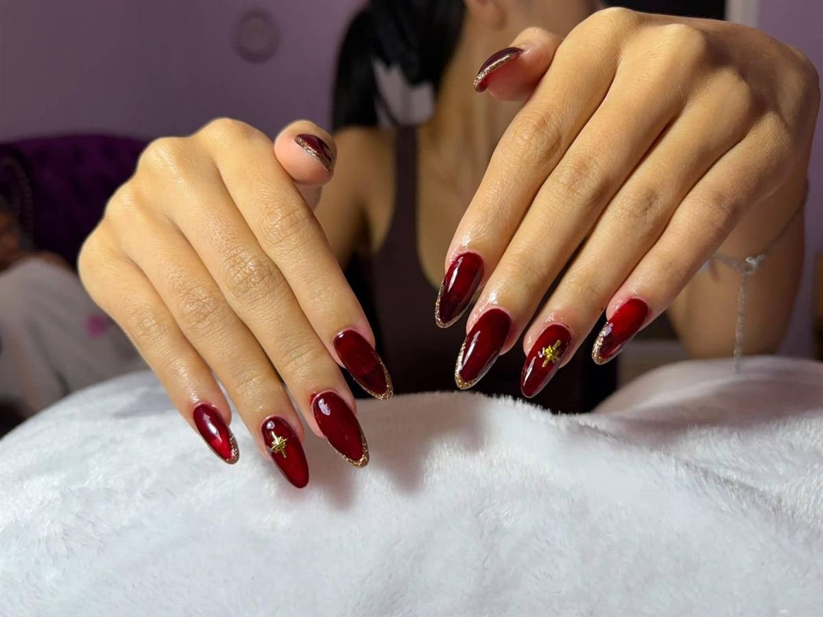 Cherry red almond nails with gold tips